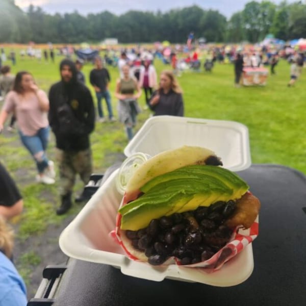 Sabrosa Venezuela's arepa with black beans and avocado, served at an outdoor event.