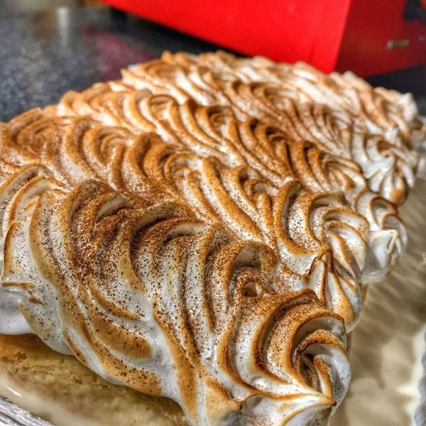 Close-up of a Sabrosa Venezuela dessert with toasted meringue swirls dusted with cinnamon.